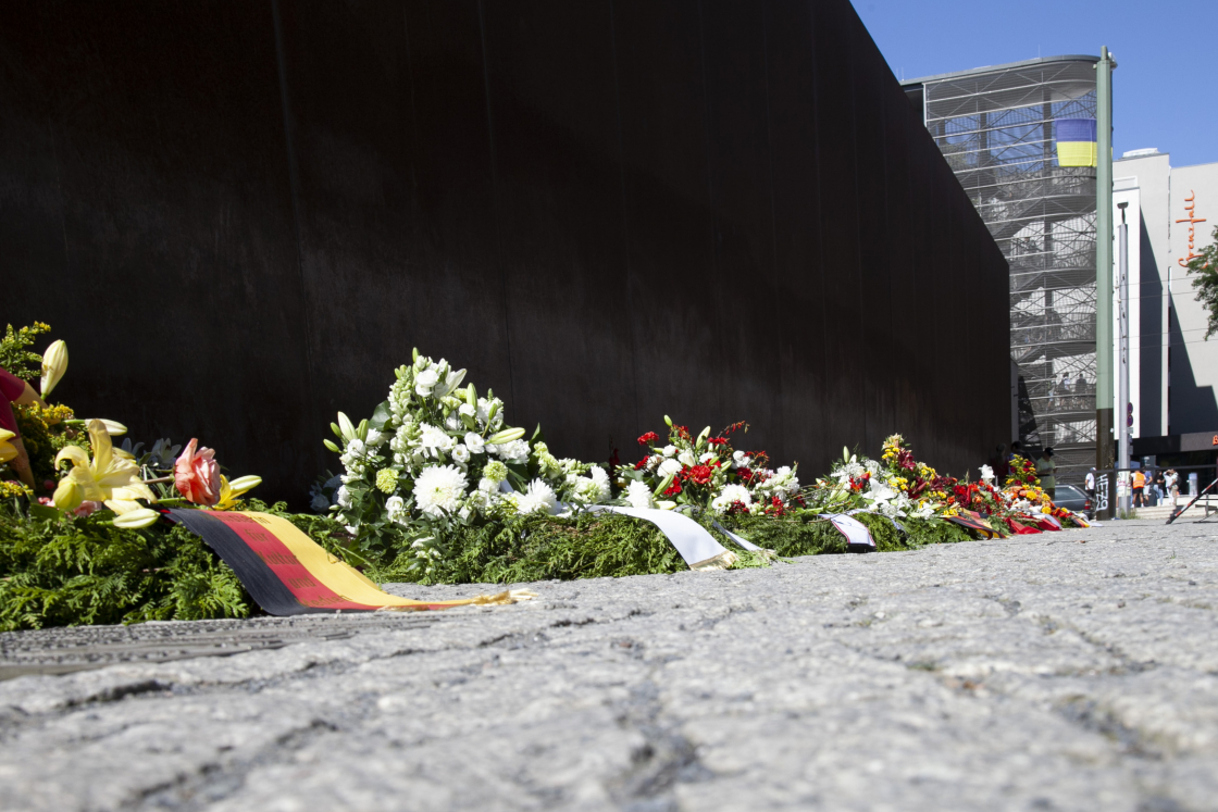 Blumenkränze an der Wand am Denkmal